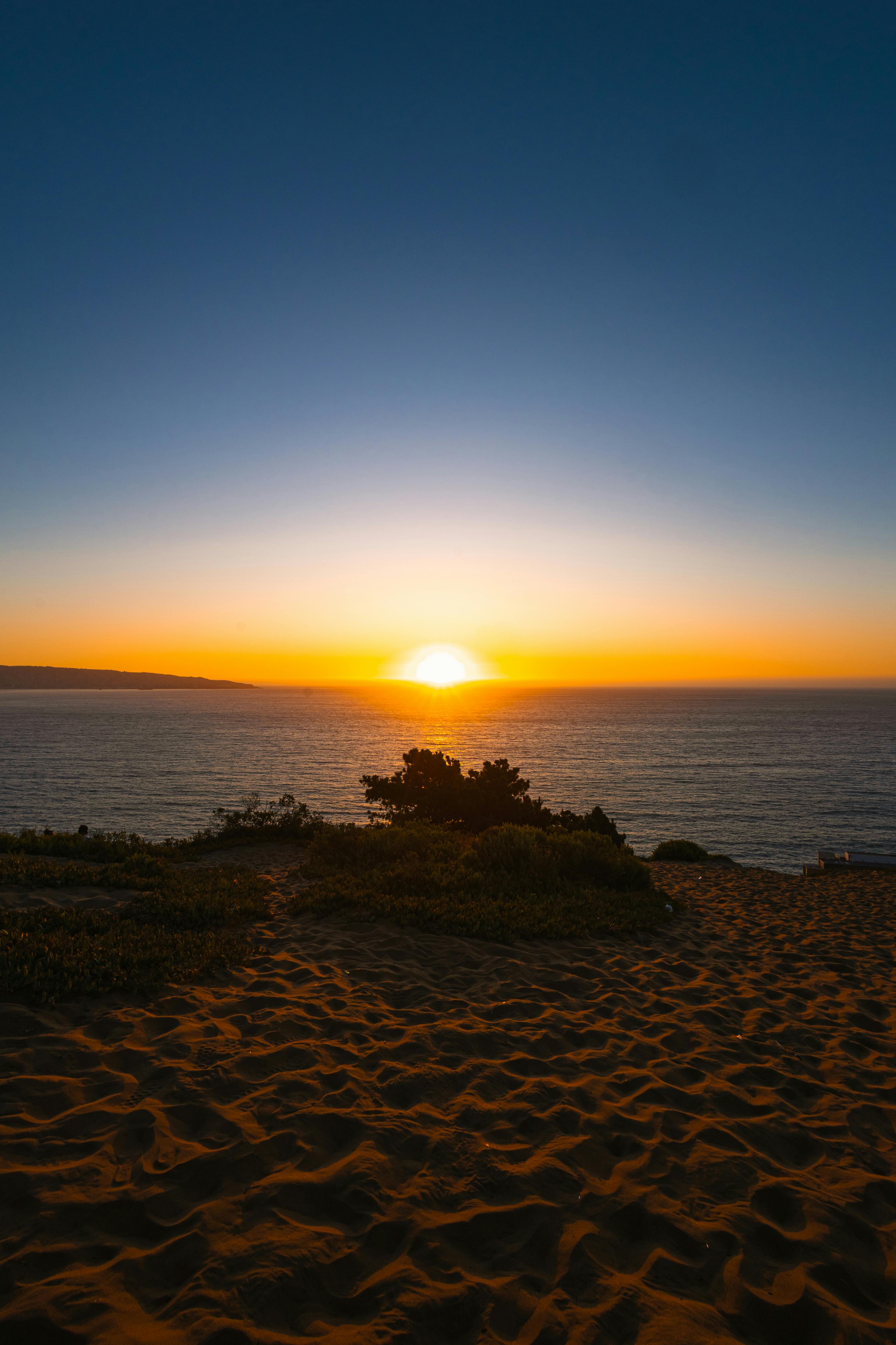 Calm ocean horizon at sunset with golden hues reflecting on the water